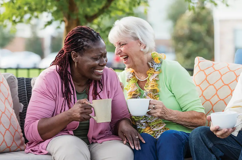 Two residents enjoying coffee outdoors.