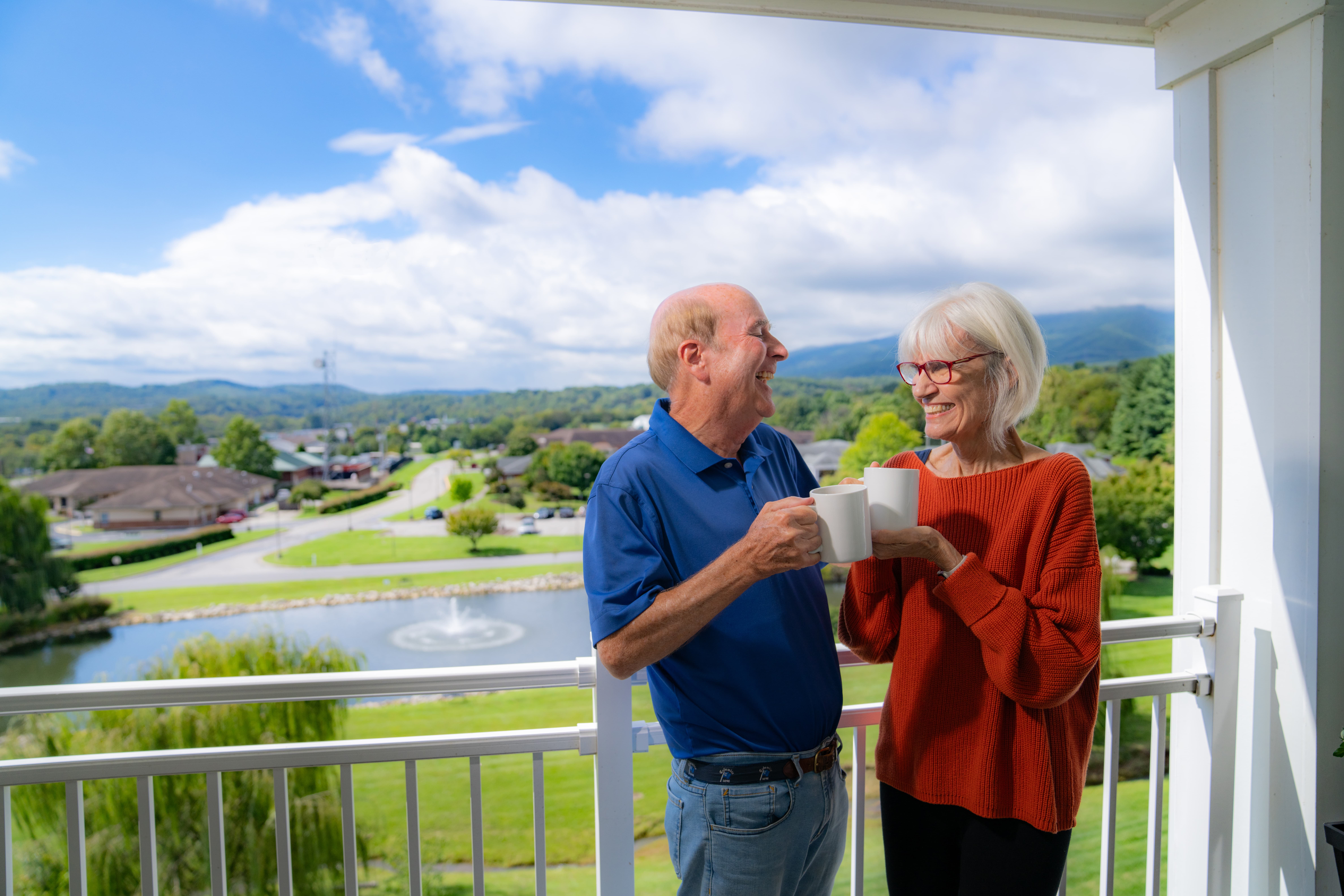 Couple enjoying coffee on a balcony with scenic views
