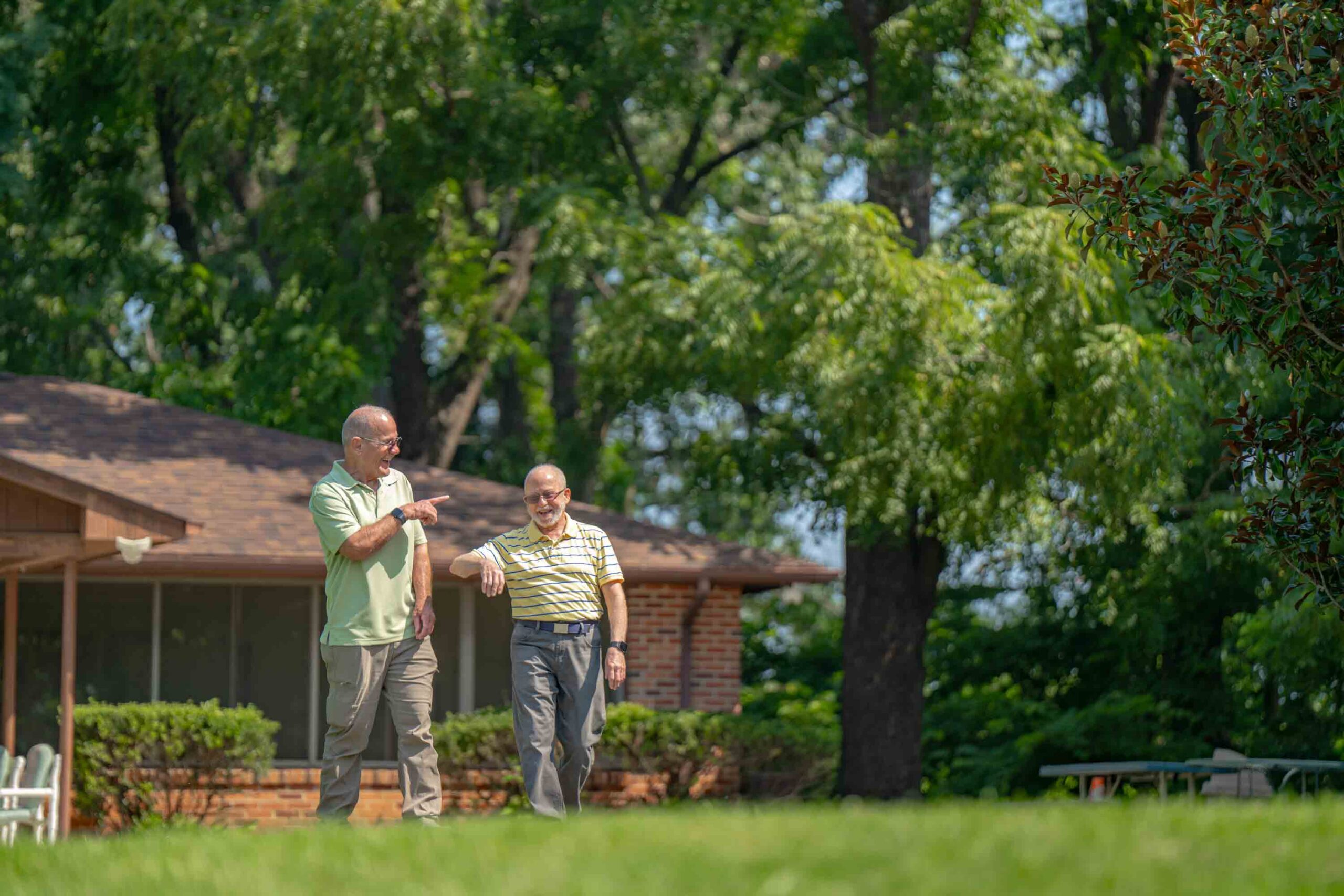 Two residents walking in a grassy area of the community