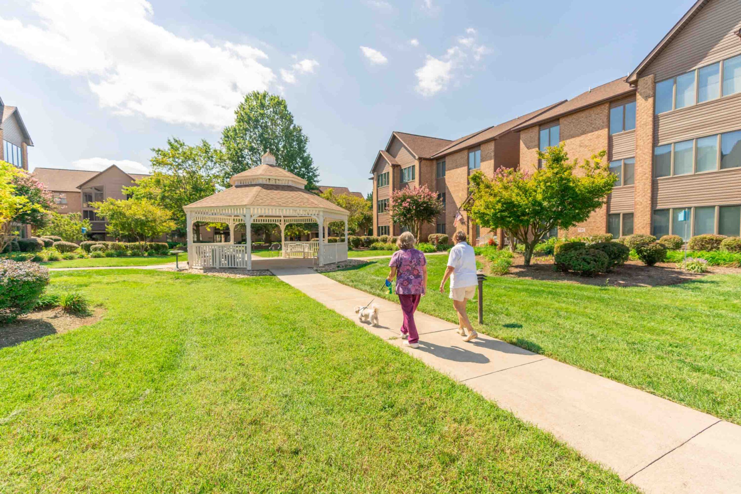 Residents walking in the garden area near the gazebo