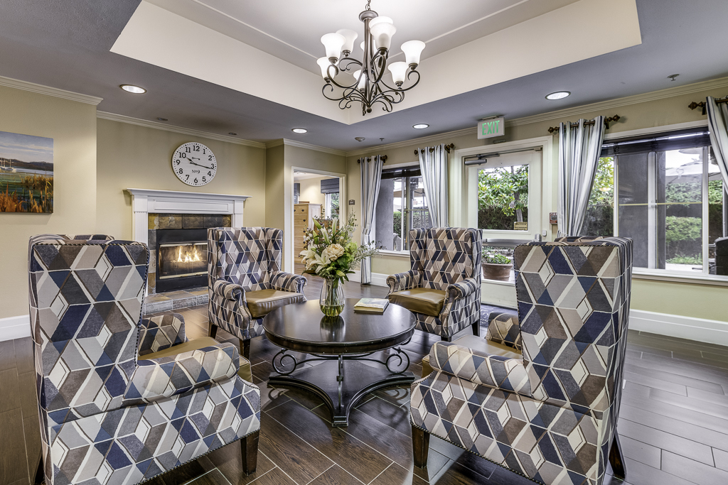 Common area in a senior living facility with a fireplace and seating
