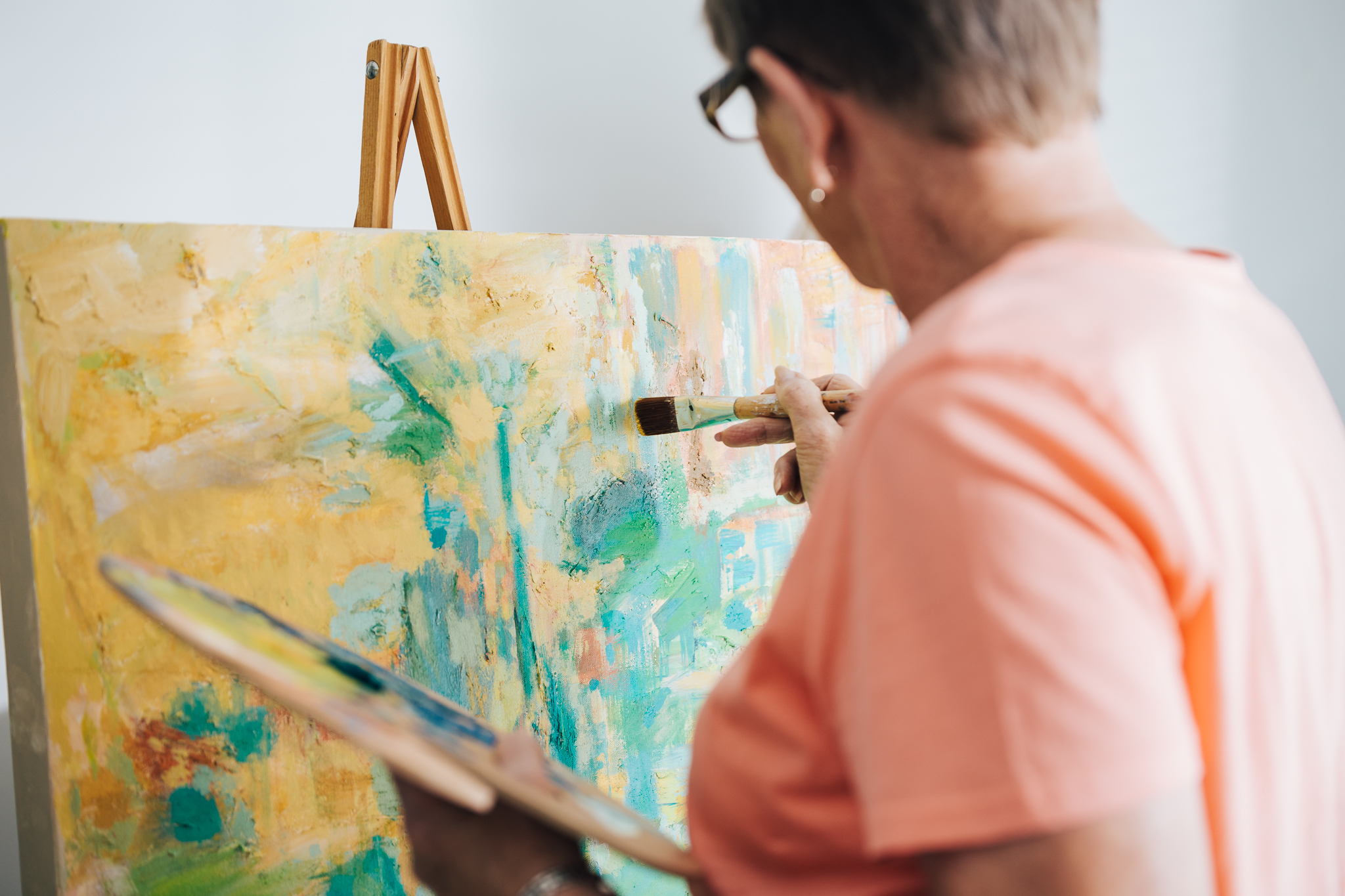 Resident painting on a canvas in an art activity