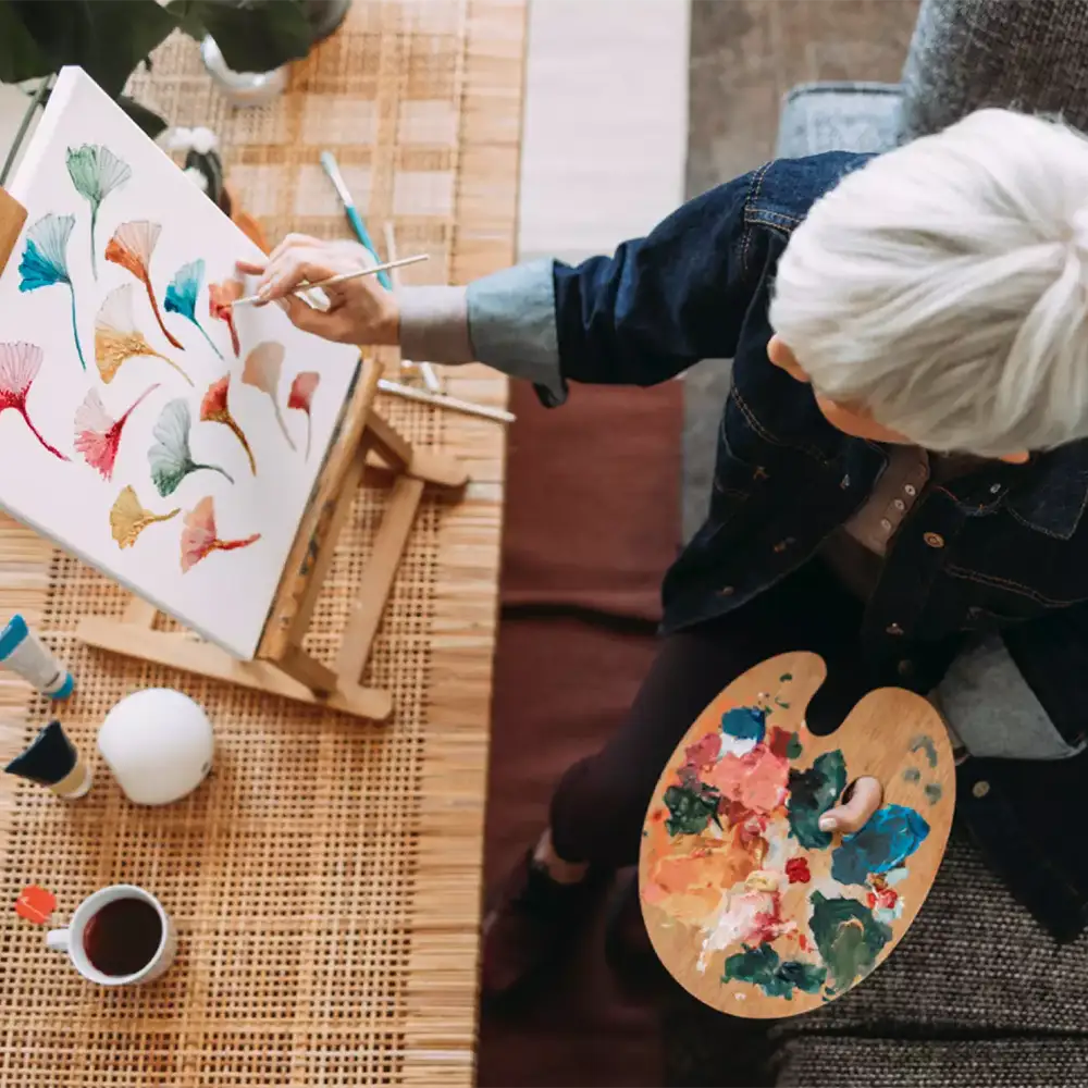 Resident painting in a bright, cozy interior
