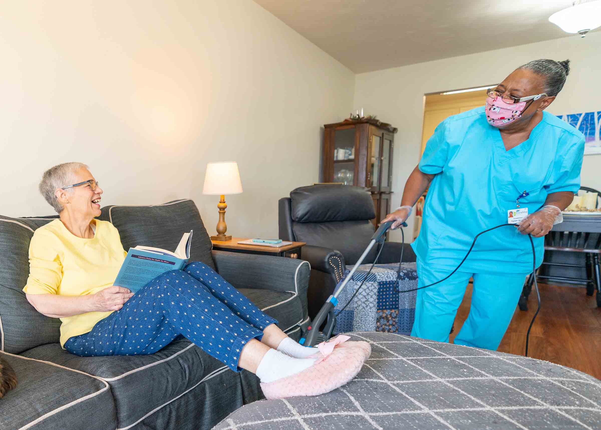 Caregiver assisting a resident in a cozy living room