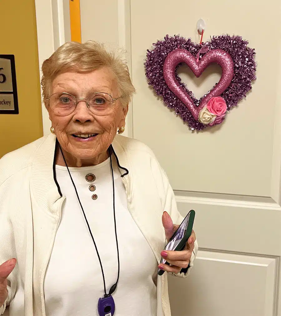 Resident smiling in front of a decorated door