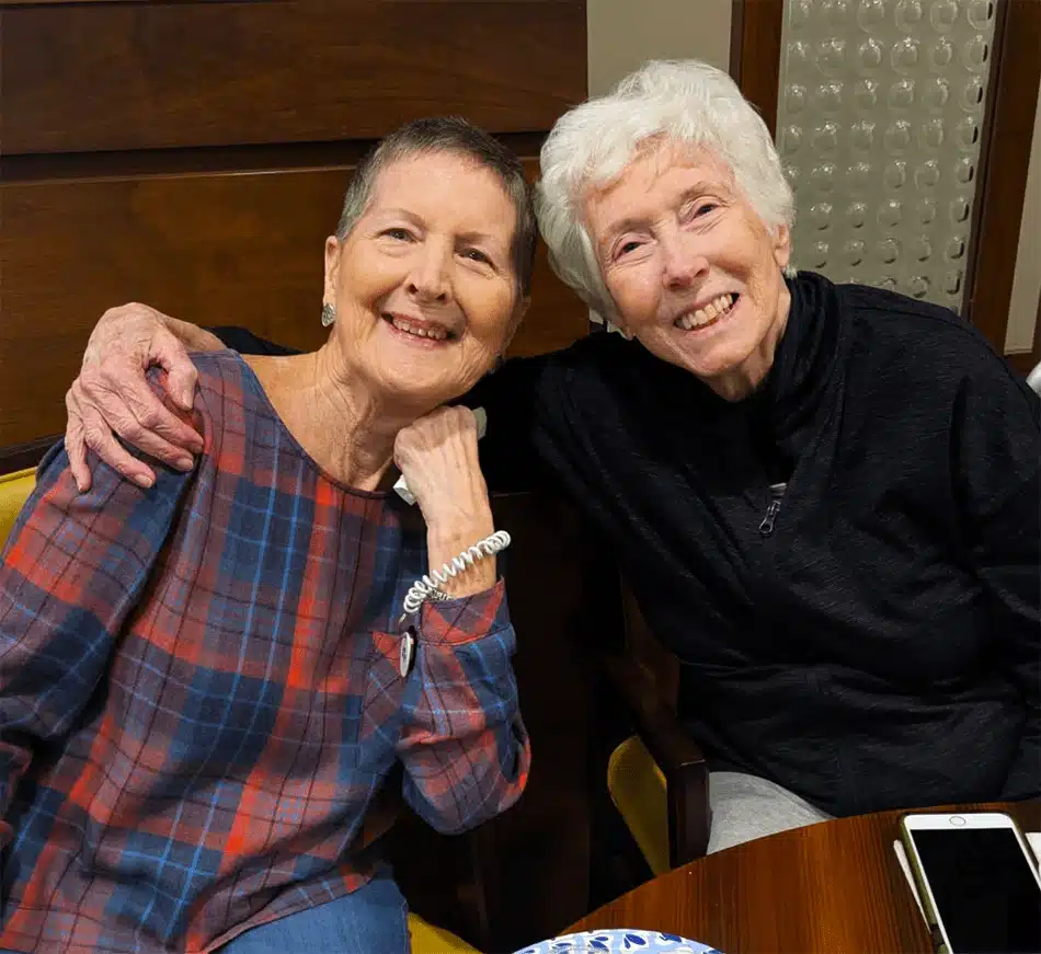 Two smiling residents enjoying time together in a common area