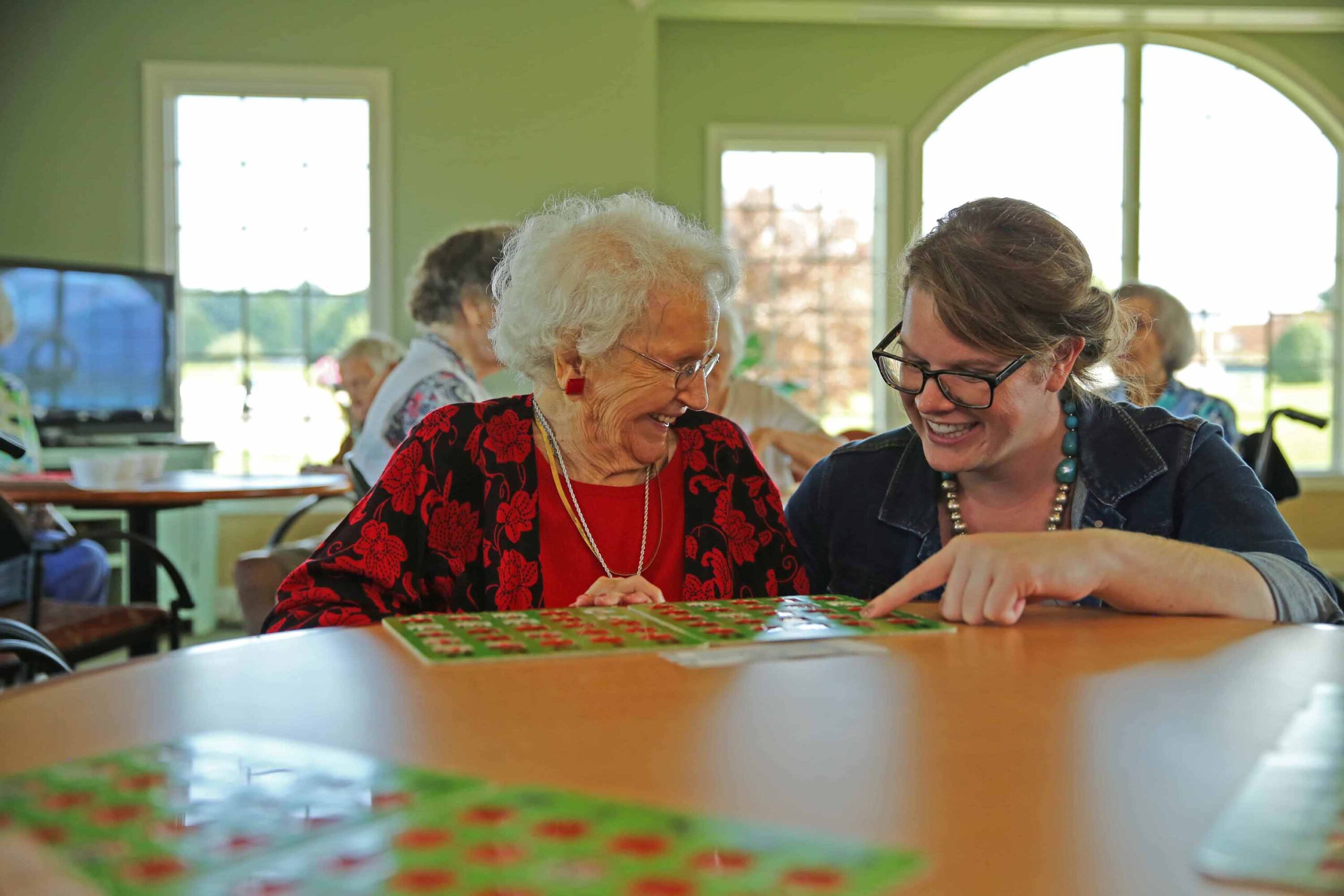 Residents enjoying a bingo game with staff assistance