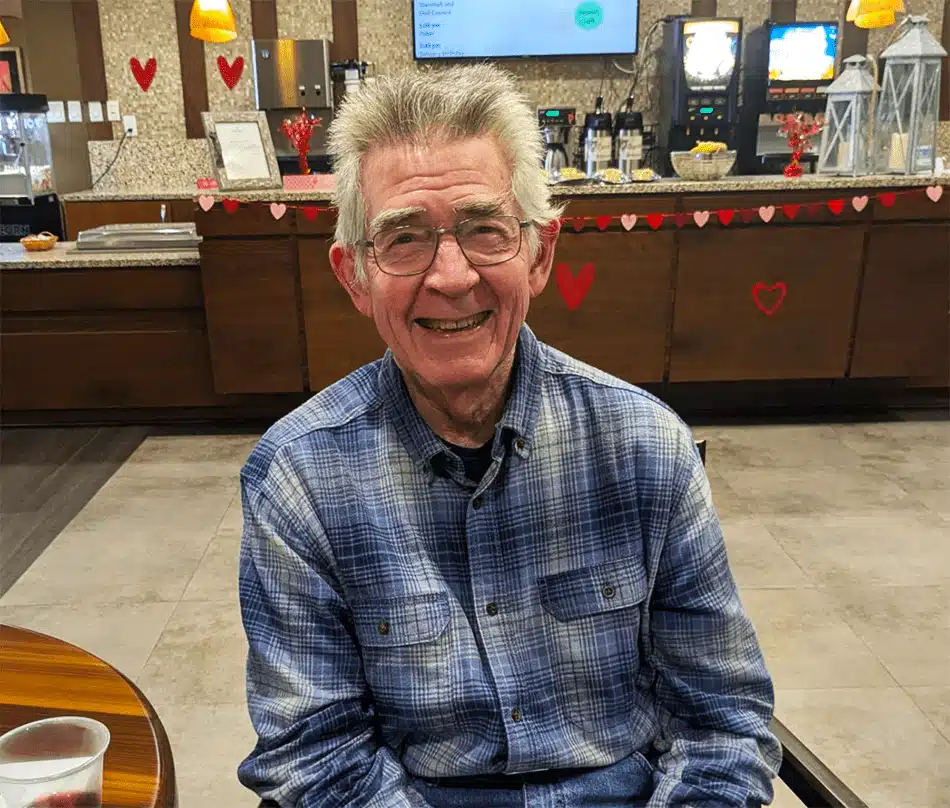 Resident smiling in a common area with decorations
