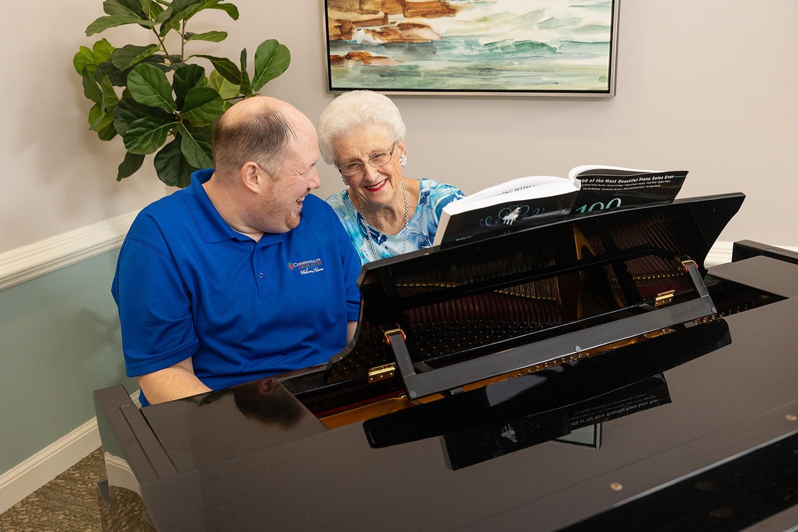 Staff member and resident enjoying music at the piano