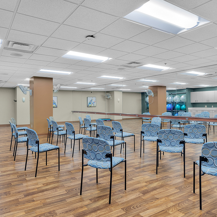 Well-lit activity room with empty chairs arranged
