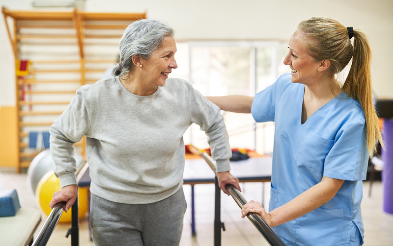 A resident interacting with staff in a rehabilitation area