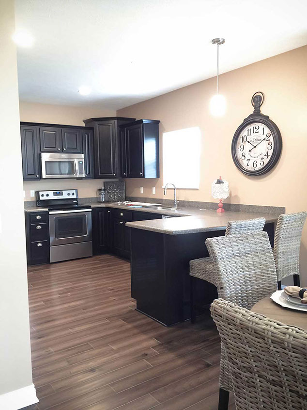 Modern kitchen interior with dark cabinets and dining area