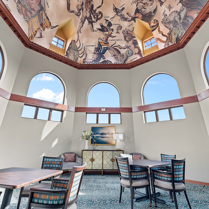 Bright common area with artistic ceiling and large windows