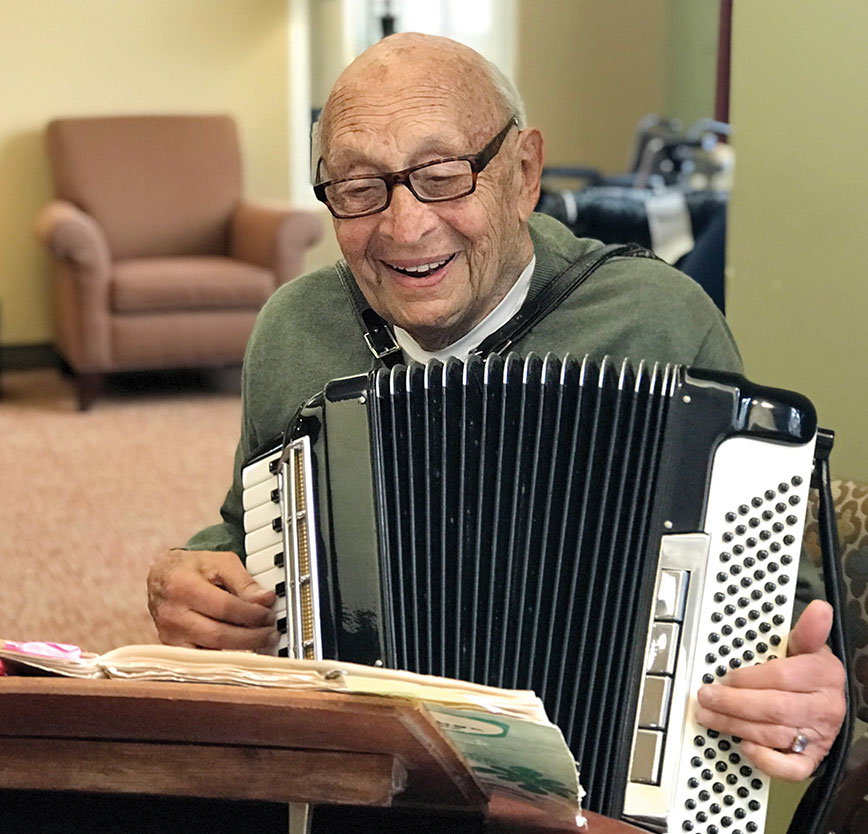 Resident playing accordion in a common area