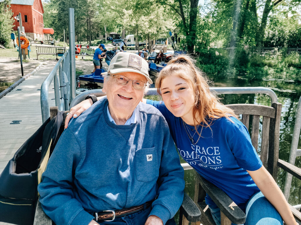 Elderly man and young woman enjoying a sunny day by the water