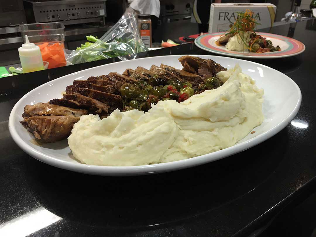 A plate of sliced chicken with mashed potatoes