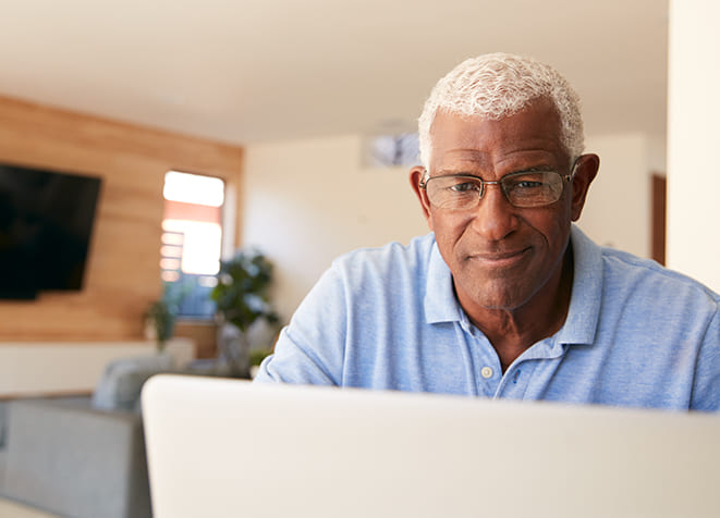 Senior man working on a laptop in a common area