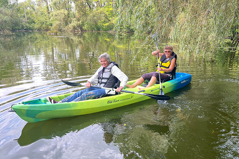 Two residents kayaking on a serene lake