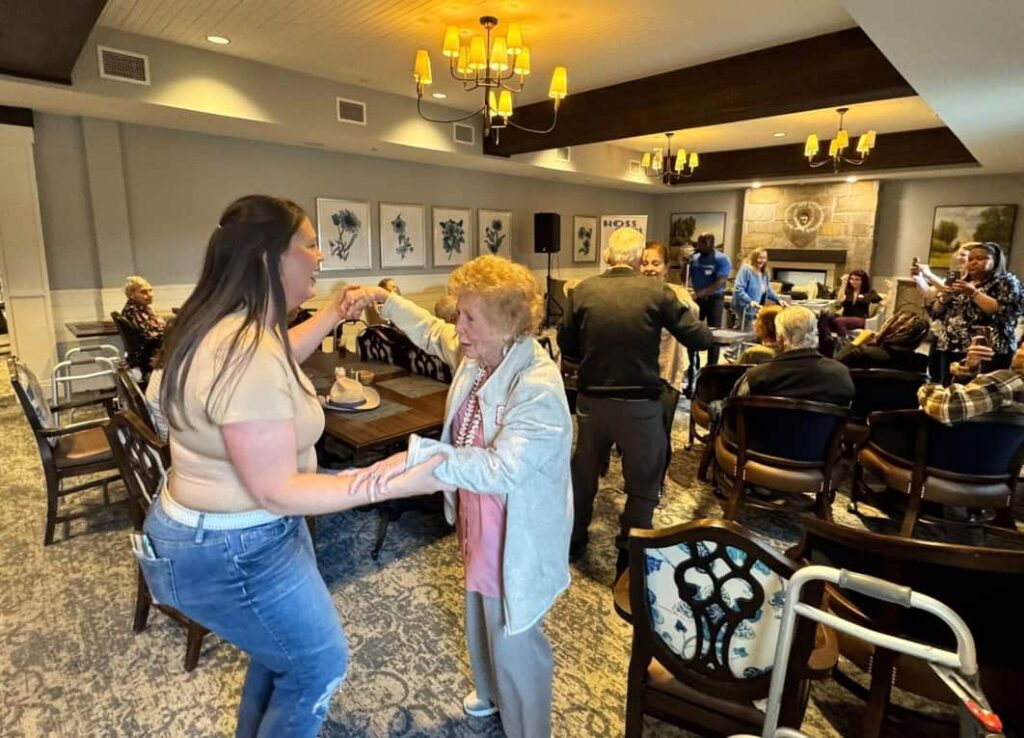 Residents dancing in a lively common area