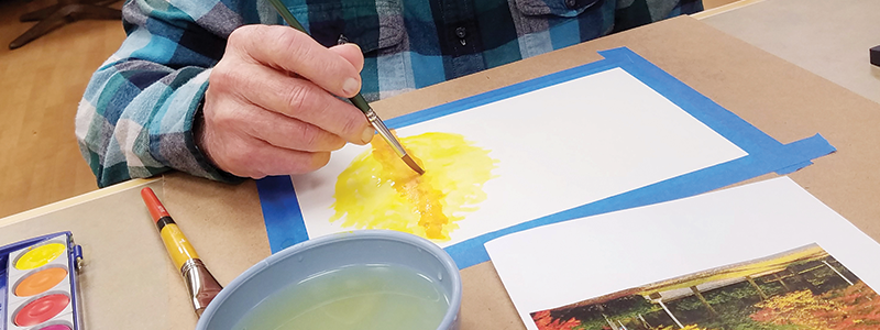 A resident painting in an art activity