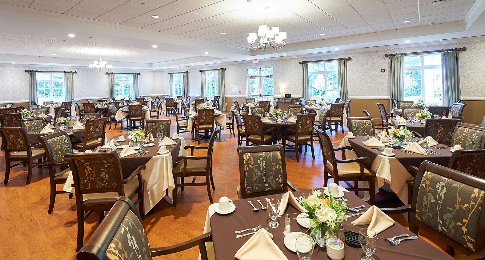 Dining area set up for a meal with flowers on tables