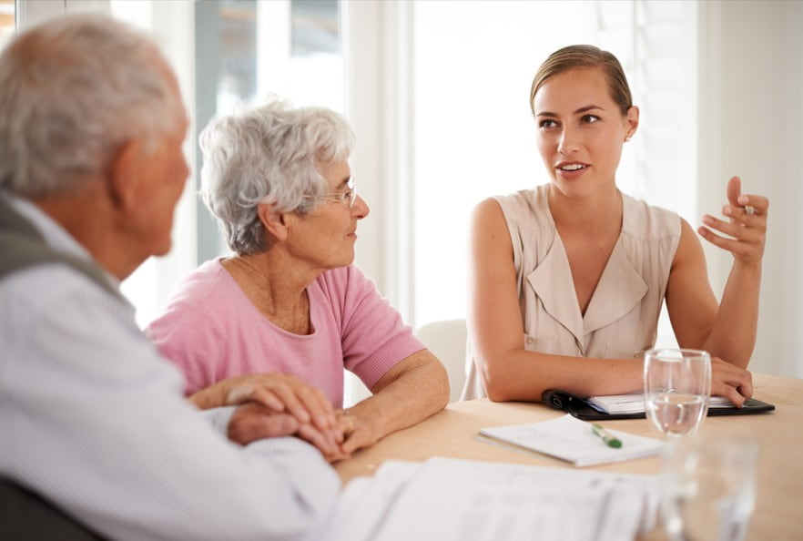 Residents and staff engaged in conversation at a table