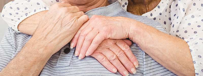 Close-up of two seniors sharing a warm embrace