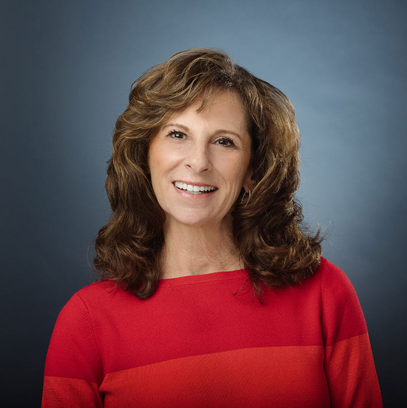 Smiling woman posing against a neutral background