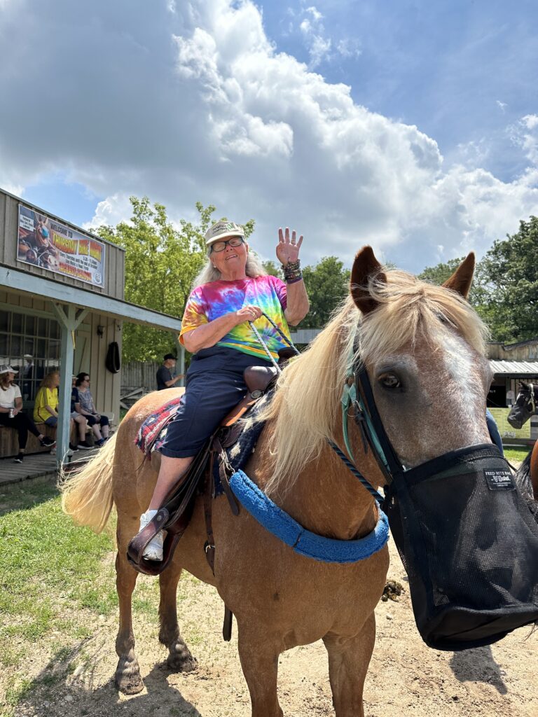 Senior resident riding a horse with a vibrant shirt