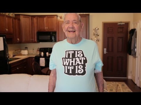 Smiling elderly man wearing a humorous t-shirt in a cozy living area