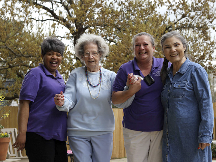 Four women enjoying time together outdoors in the facility's garden