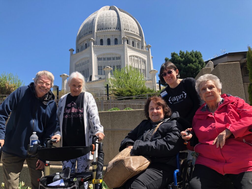 Residents and staff posing outdoors in front of a building