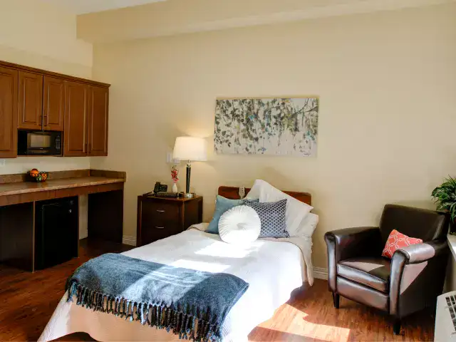 Bright, cozy resident room with a bed and amenities