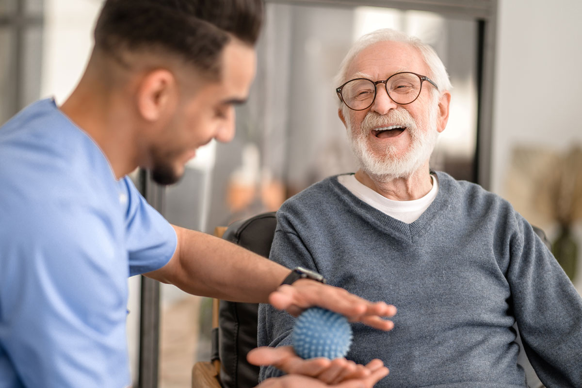 A caregiver playing with a smiling resident