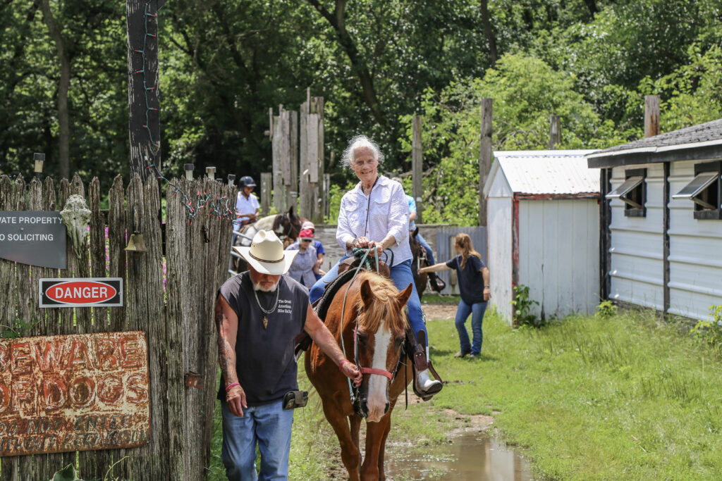 Residents enjoying horseback riding at a senior care facility