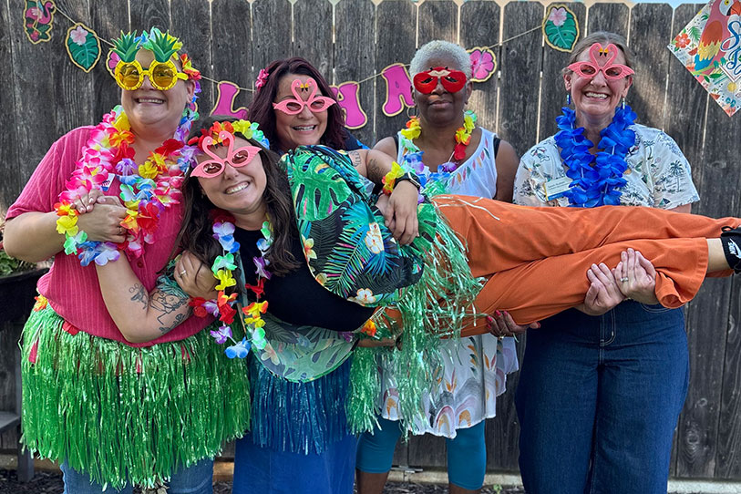Residents and staff celebrating with leis and sunglasses