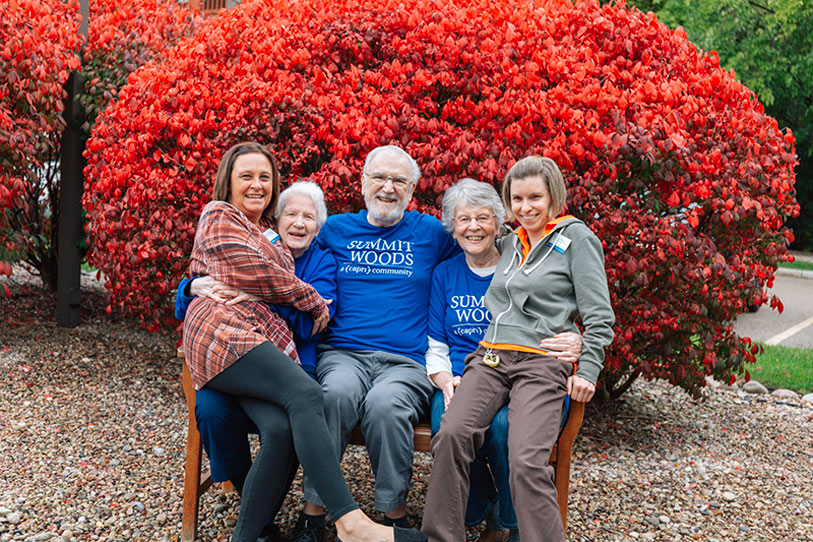 Residents enjoying outdoor time with staff in vibrant foliage