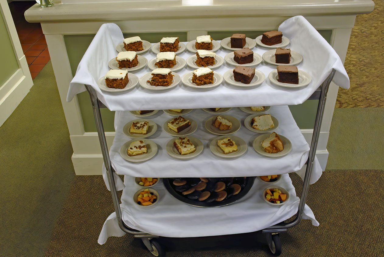 Dessert cart with various cakes and fruit cups