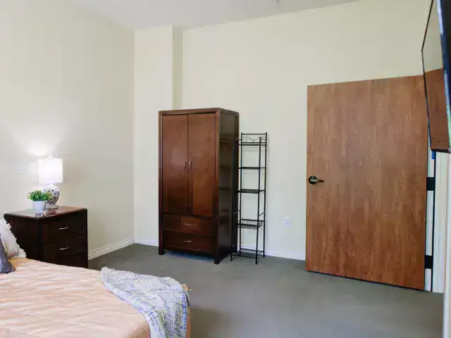 A private resident room with a bed and wardrobe