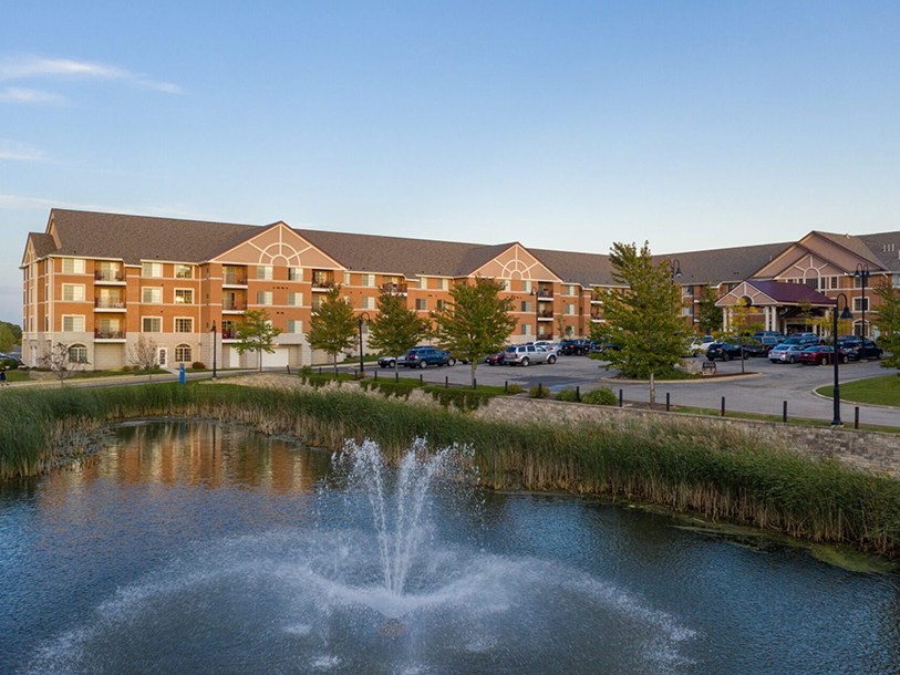 Building exterior view with a fountain and parking lot