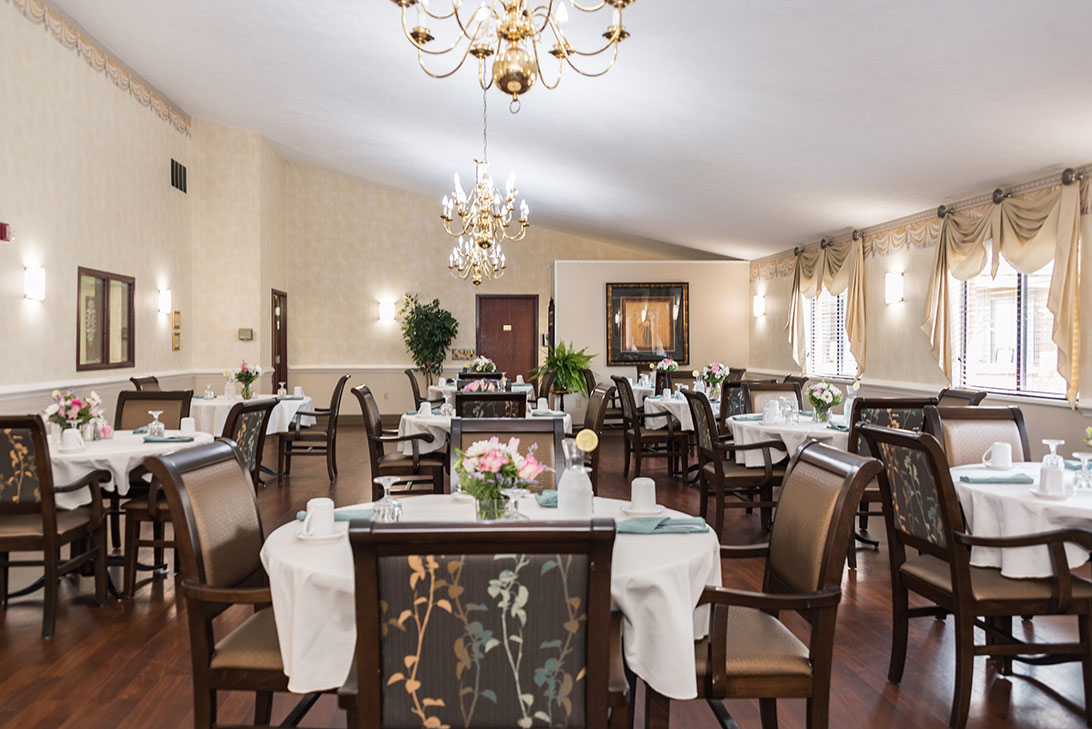 Elegant dining room with tables set for residents