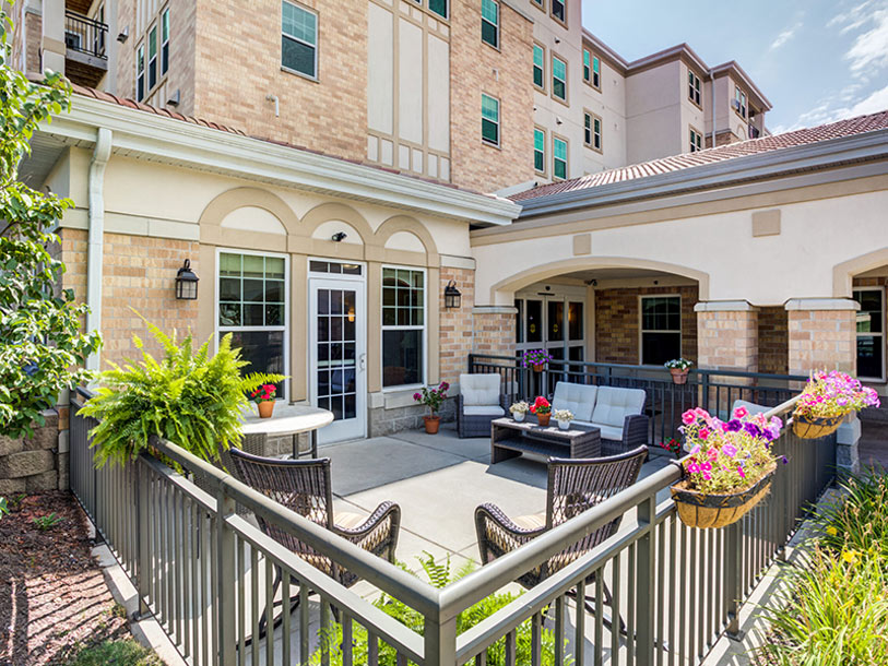 Outdoor seating area with plants and comfortable chairs