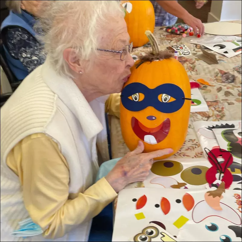 Elderly resident decorating a pumpkin during an activity
