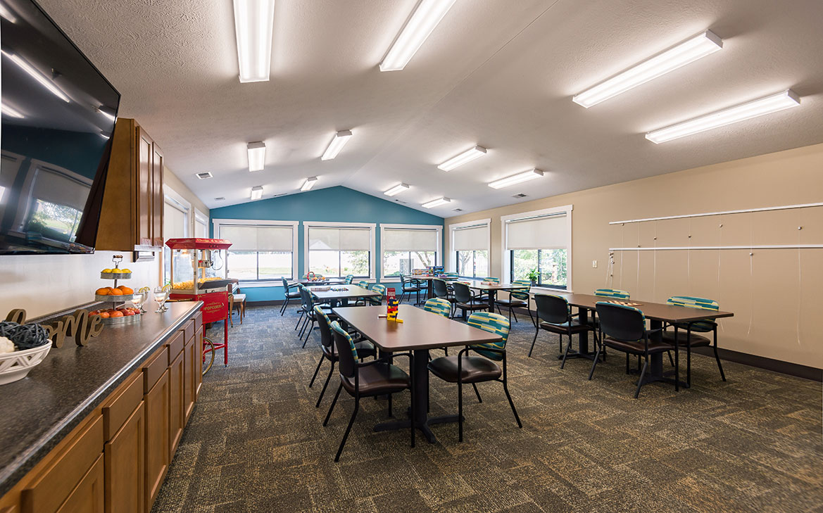 Interior view of a bright common area with tables and chairs