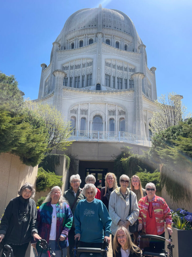 Group of residents and staff in front of a large building