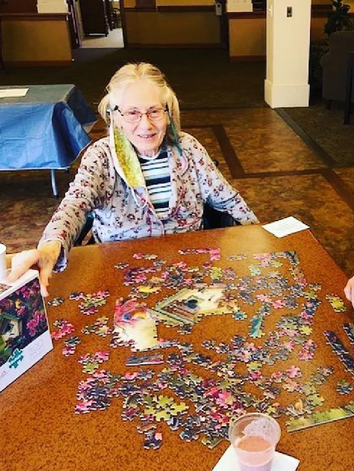 Resident enjoying a jigsaw puzzle in the common area