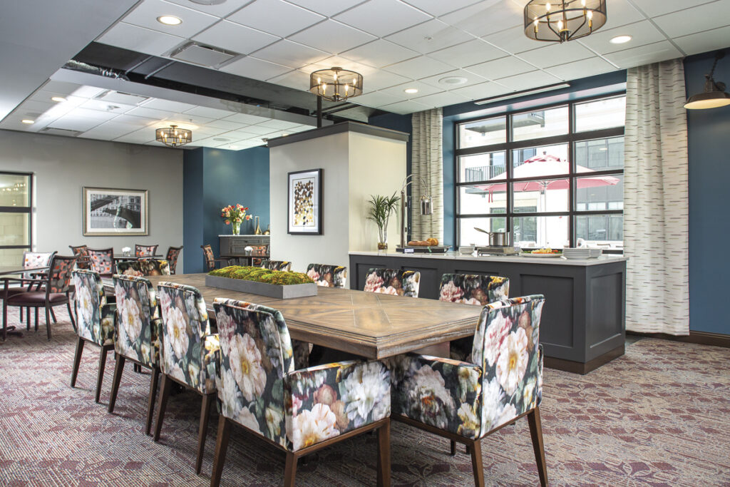 Bright dining room with floral chairs and large windows