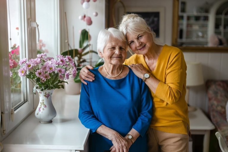 Two smiling women in a bright common area