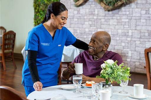 Staff member serving coffee to a resident in the dining area