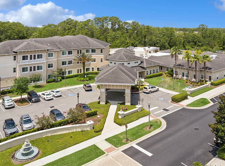 Aerial view of the assisted living facility with parking and gardens